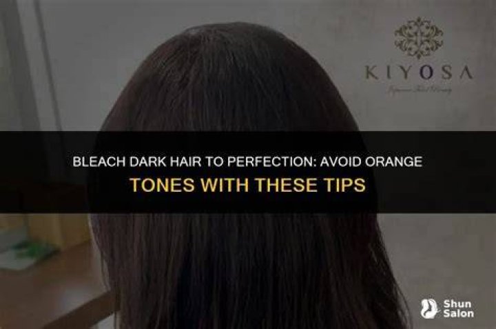 How do you bleach dark hair without turning it orange?